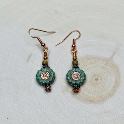 Copper jewelry earrings with flowers on a wooden background