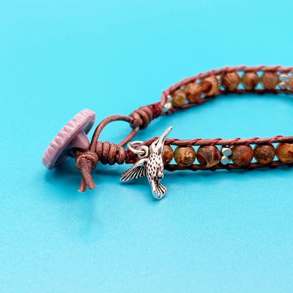 Bracelet with a hummingbird charm on a blue background