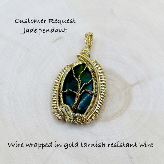 Jade pendant wire wrapped in gold tarnish resistant wire on a light background