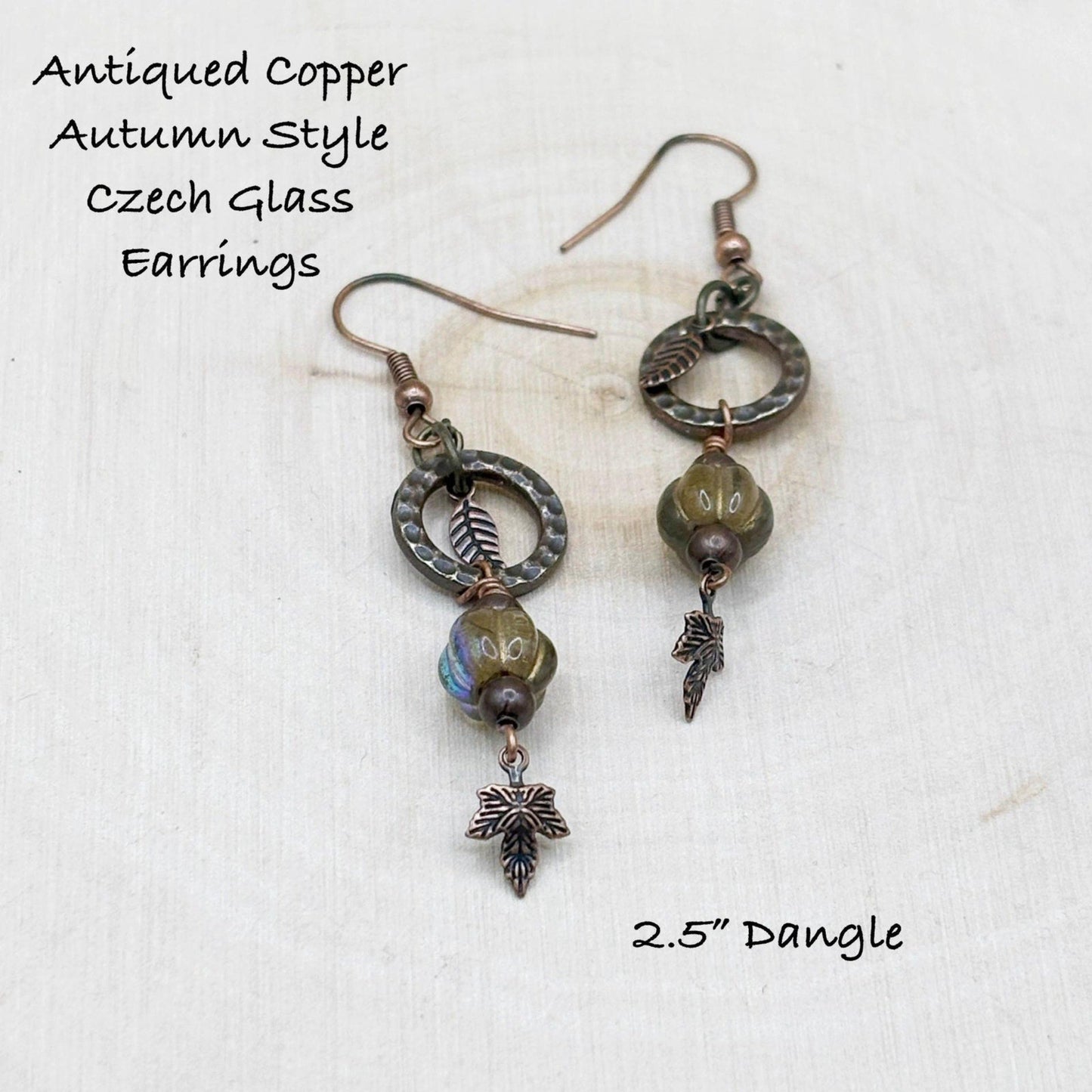 Antiqued copper Czech glass earrings on a white background with text describing the style and dangle length.