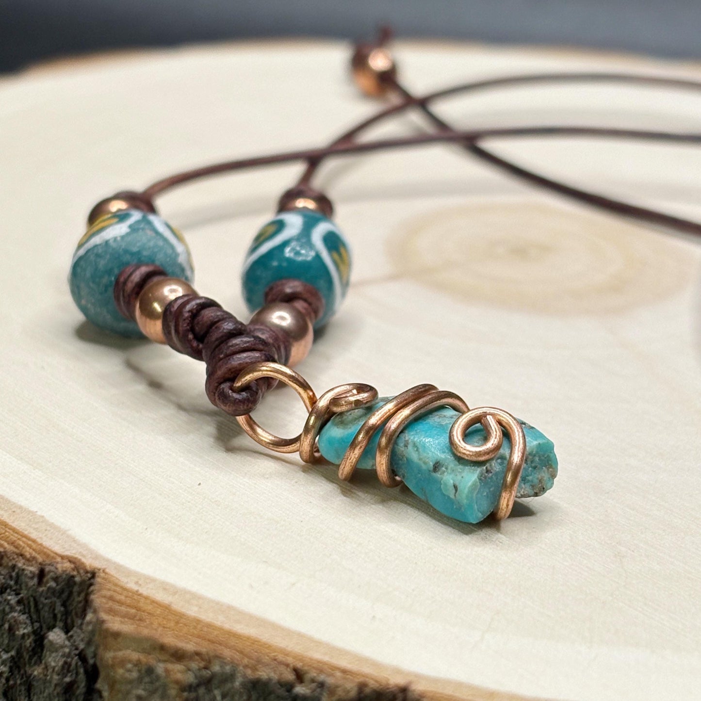 Necklace with turquoise beads and copper accents on a wooden surface