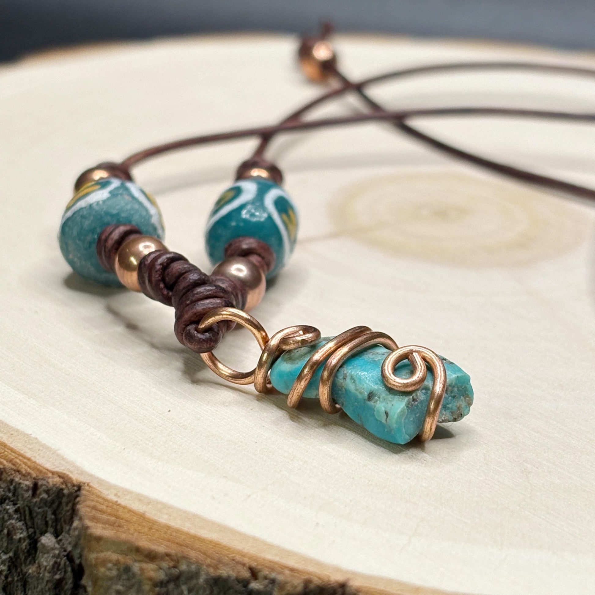 Necklace with turquoise beads and copper accents on a wooden surface