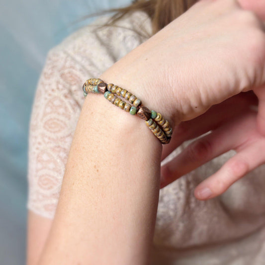 Close-up of a wrist wearing a beaded bracelet with a blurred background-p