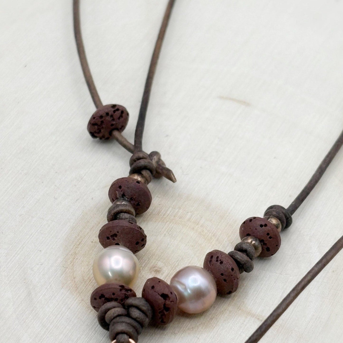 Necklace with brown beads and pearls on a light background