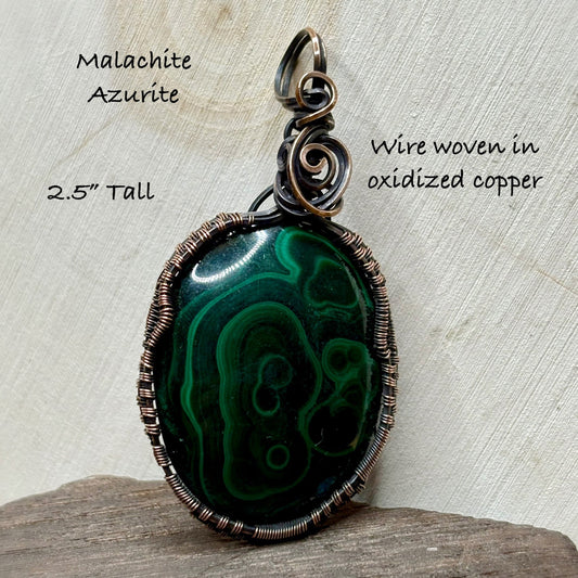 Green stone wire wrapped in antiqued copper sitting on wooden background