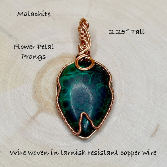 Malachite pendant with flower petal prongs on a textured surface