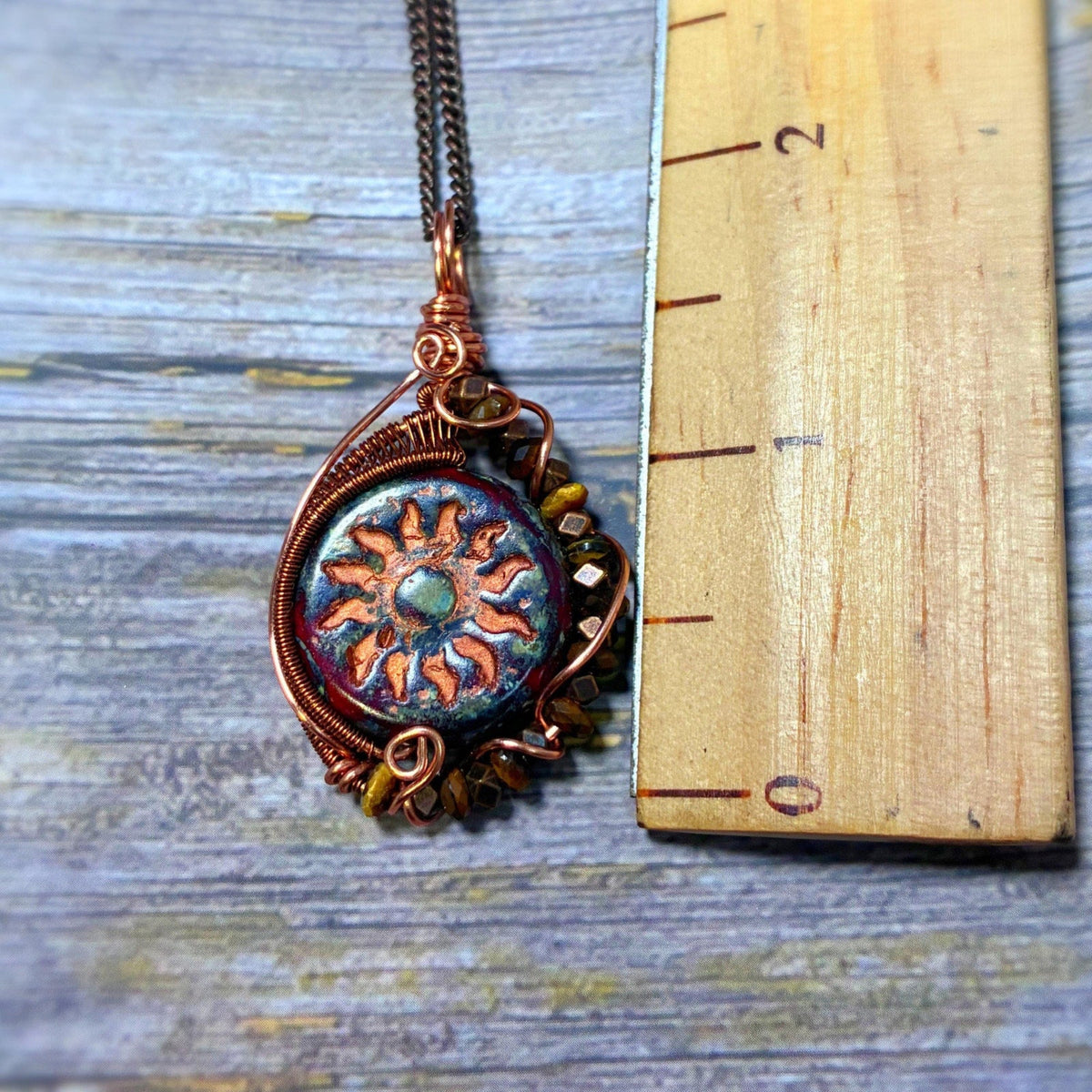 Ruler that is wooden sitting next to the pendant 