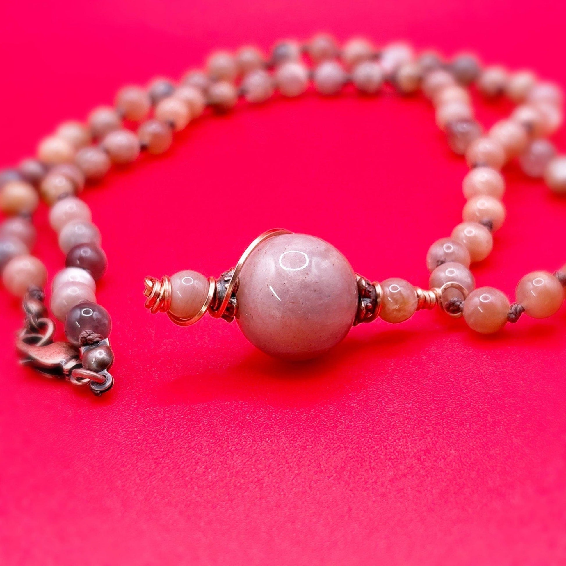 Necklace with pink beads on a red background