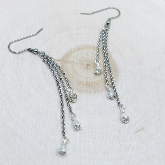 Silver chain earrings on a light wood background-p