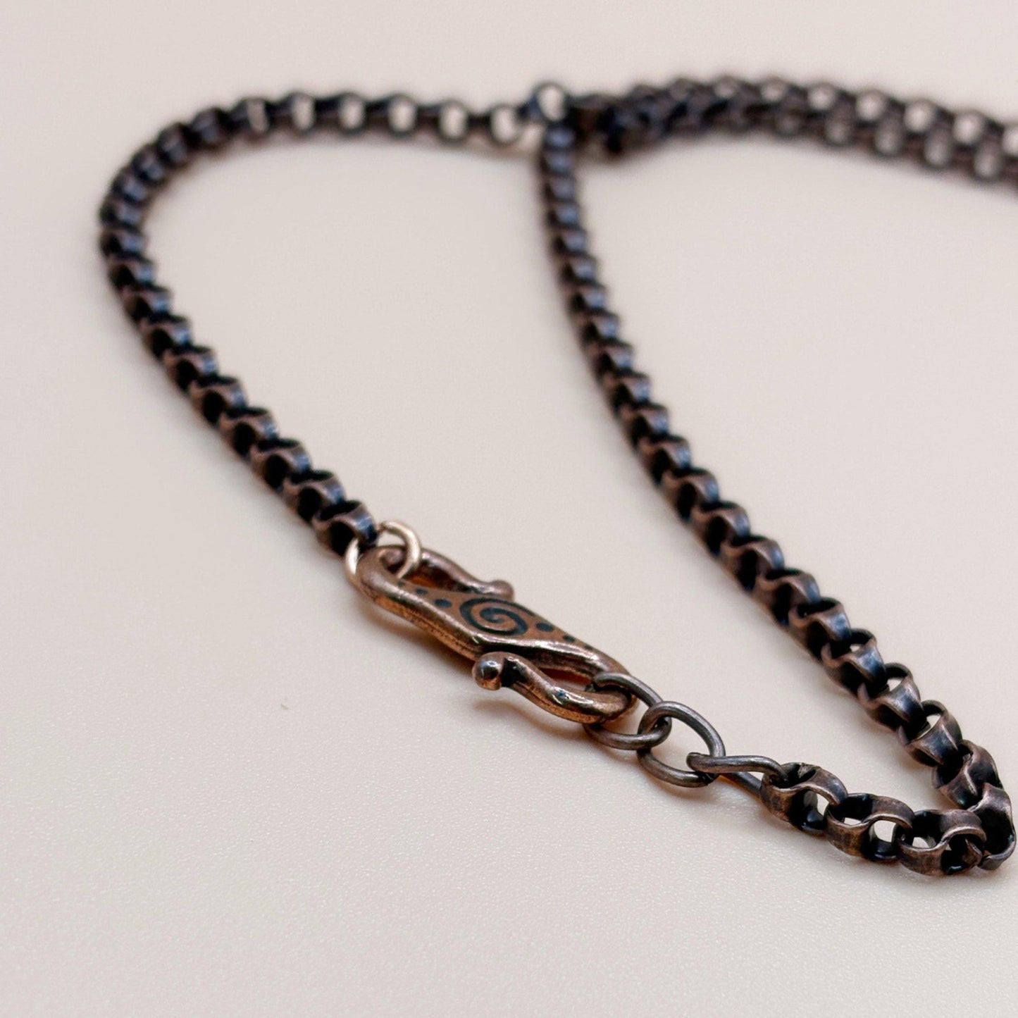 Close-up of a chain necklace with a clasp on a light background