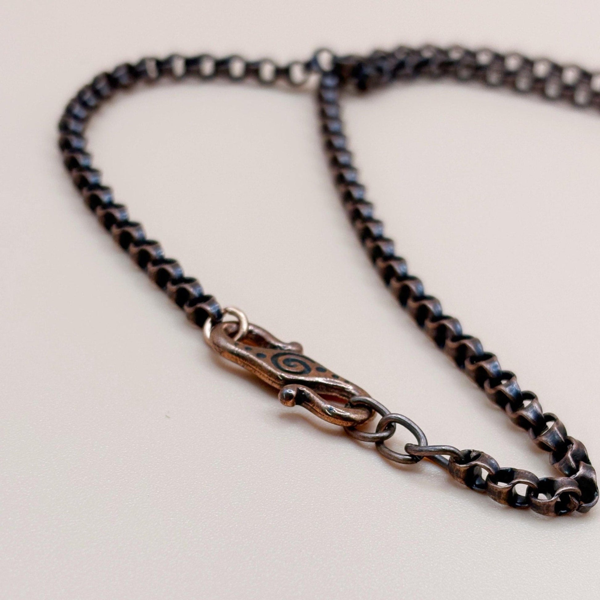 Close-up of a chain necklace with a clasp on a light background
