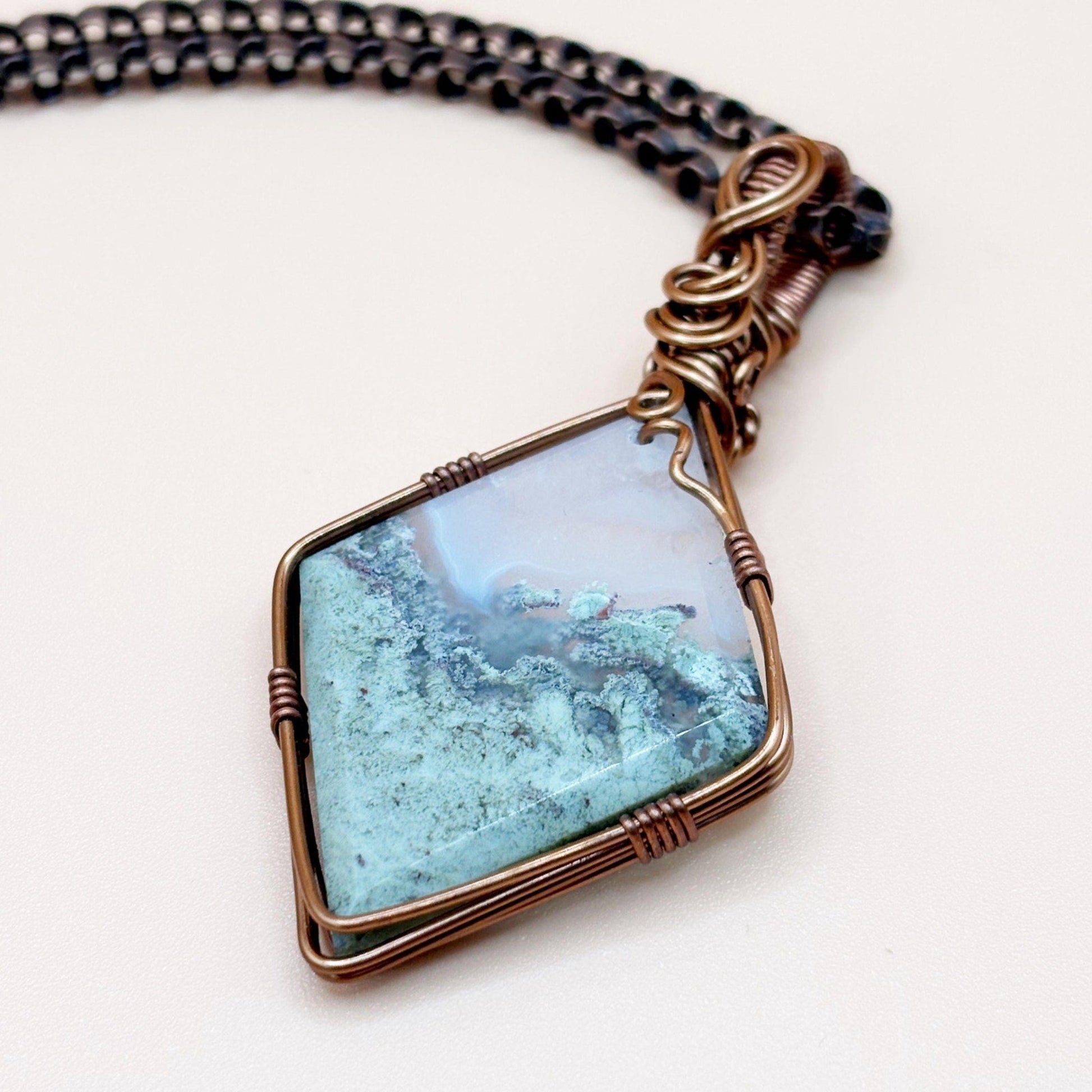 Necklace with a Moss Agate stone pendant on a white background