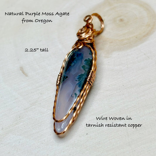 Natural Purple Moss Agate pendant with wire wrapping on a textured white background