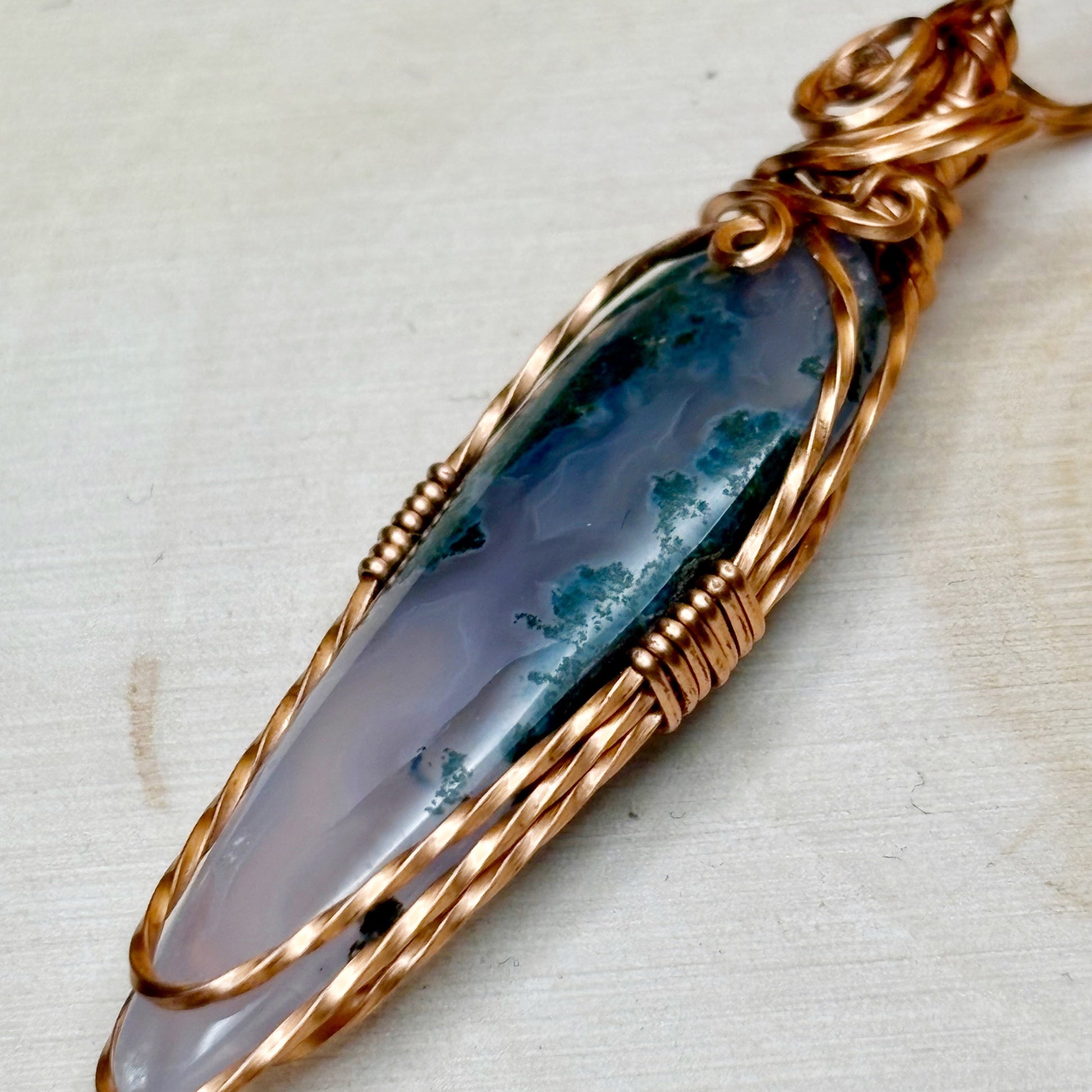 handmade wire wrapped copper pendant featuring purple and white moss agate