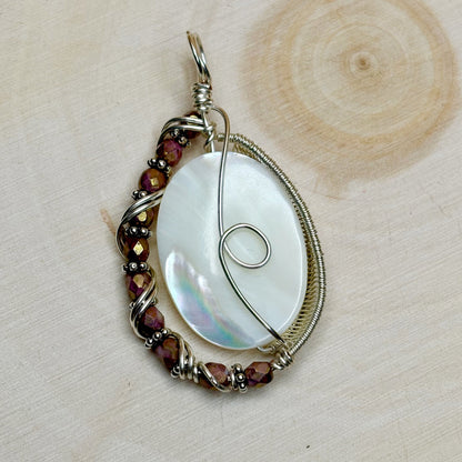 Silver wire wrap pendant featuring a mother of pearl shell