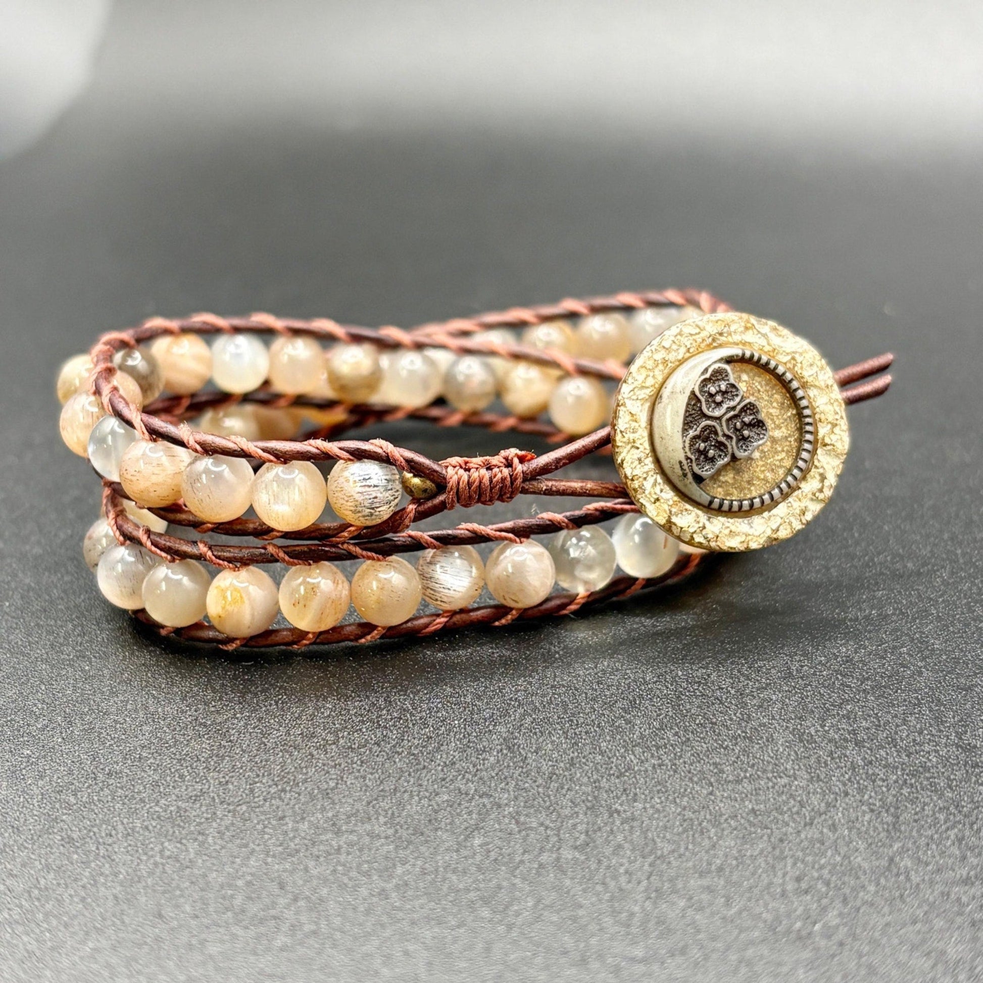 Multistrand beaded bracelet with a decorative clasp on a gray background