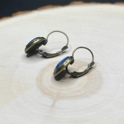 Pair of earrings with blue stones on a textured surface