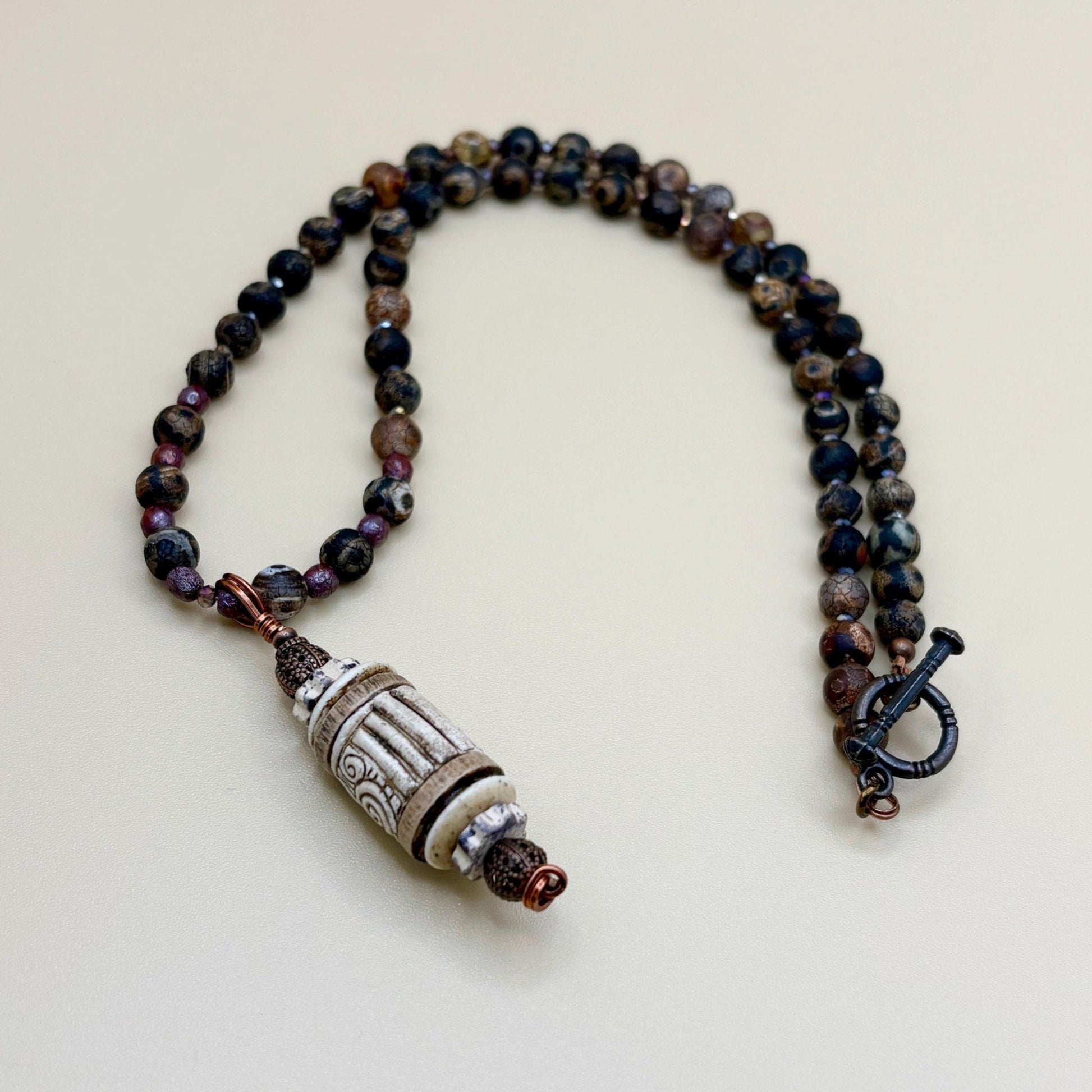 Beaded necklace with a decorative clasp on a light background