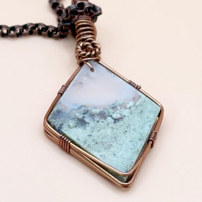 Necklace with a square pendant featuring a natural landscape design on a light background
