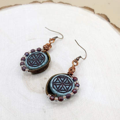 Pair of earrings with intricate design on a white surface