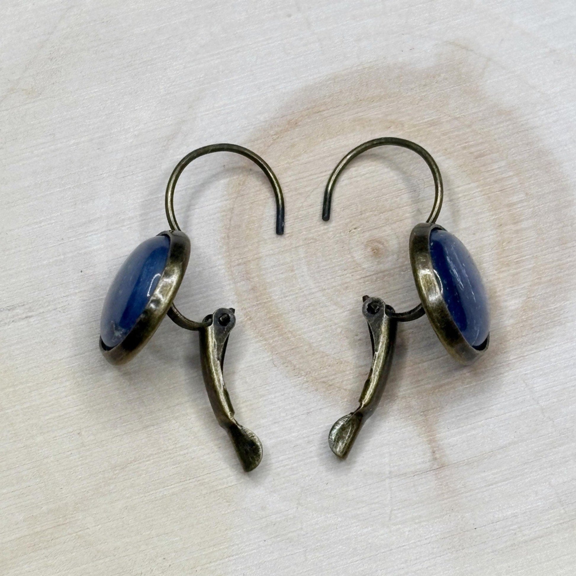 Pair of earrings with blue stones on a light wooden surface