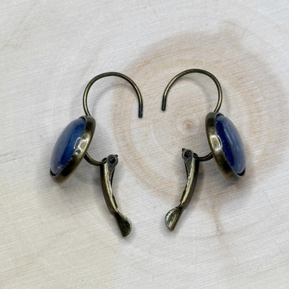 Pair of earrings with blue stones on a light wooden surface