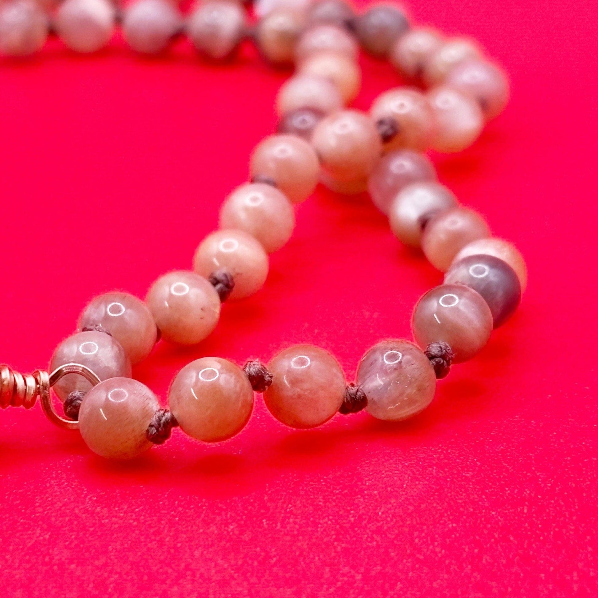 Necklace with pink beads on a red background