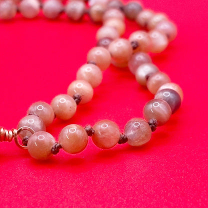 Necklace with pink beads on a red background