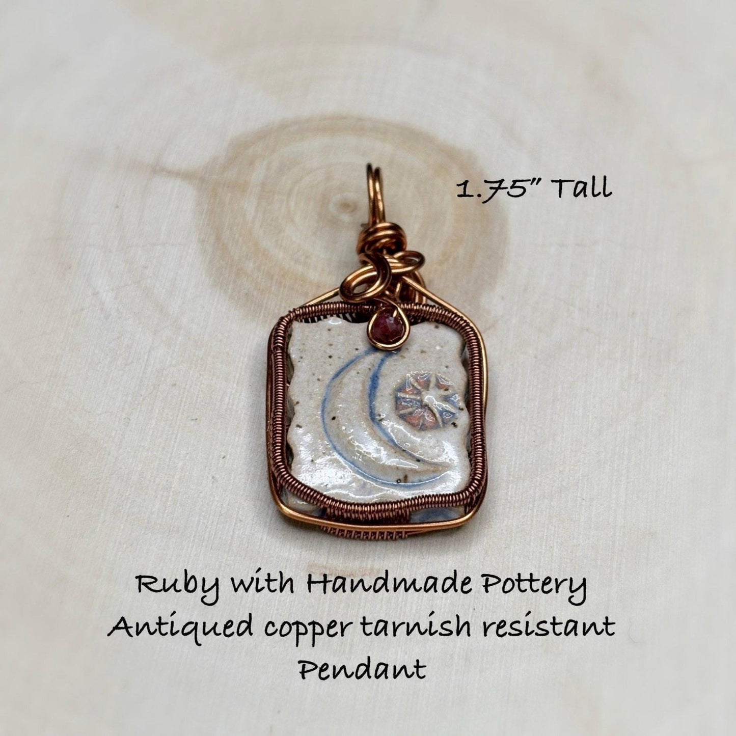 Handmade pendant with antiqued copper tarnish resistant on a white fabric background