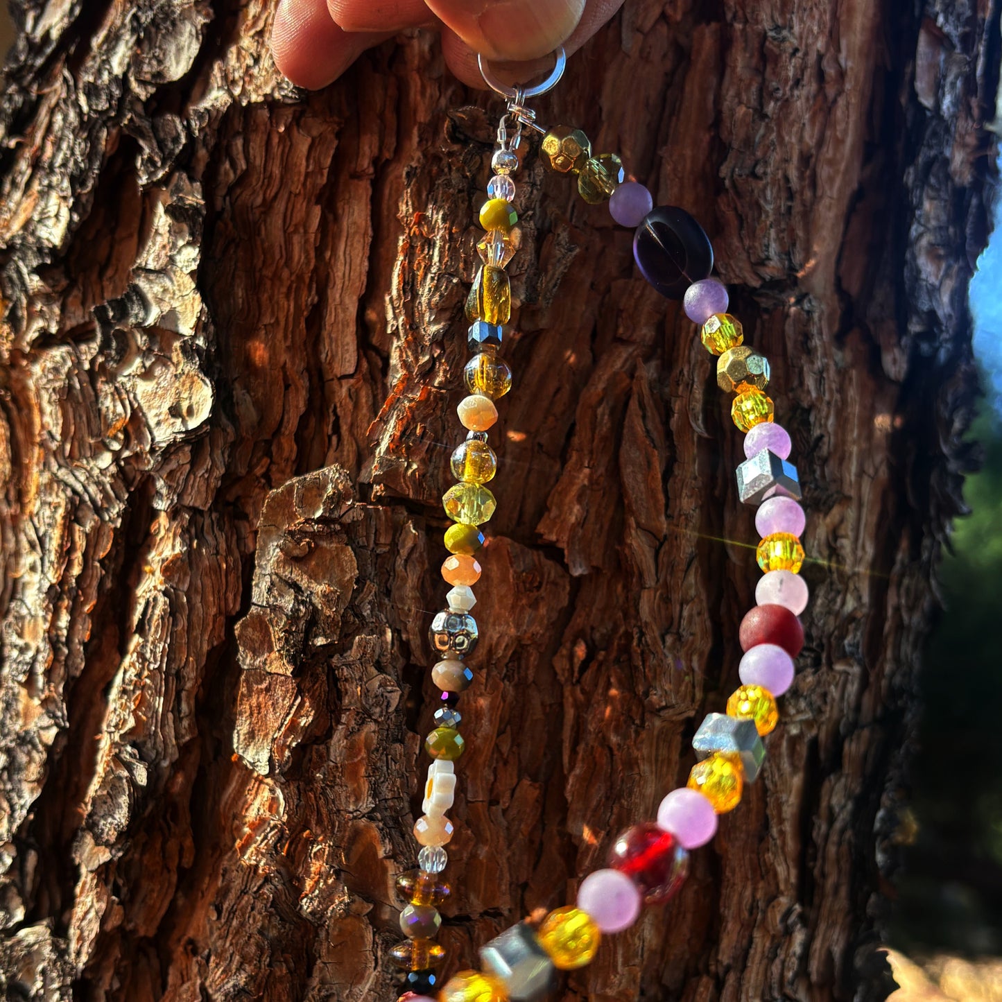 Colorful beaded light catcher hanging on a tree branch