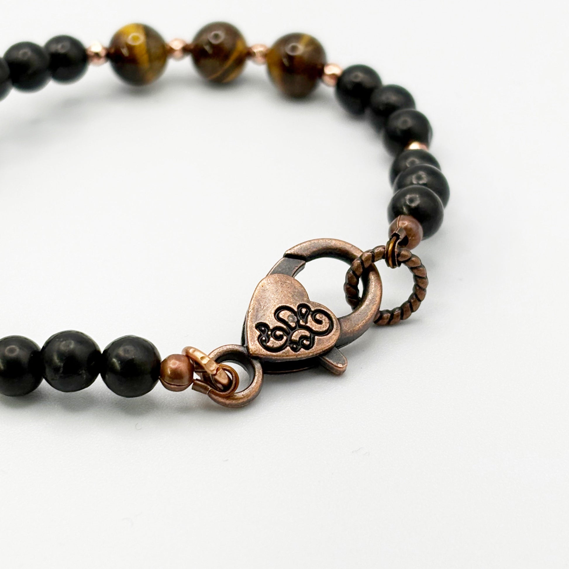 Necklace with black beads and a heart-shaped clasp on a white background