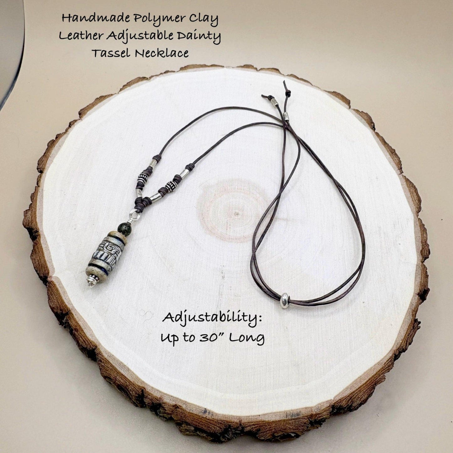 Handmade polymer clay necklace with tassel on a wooden surface