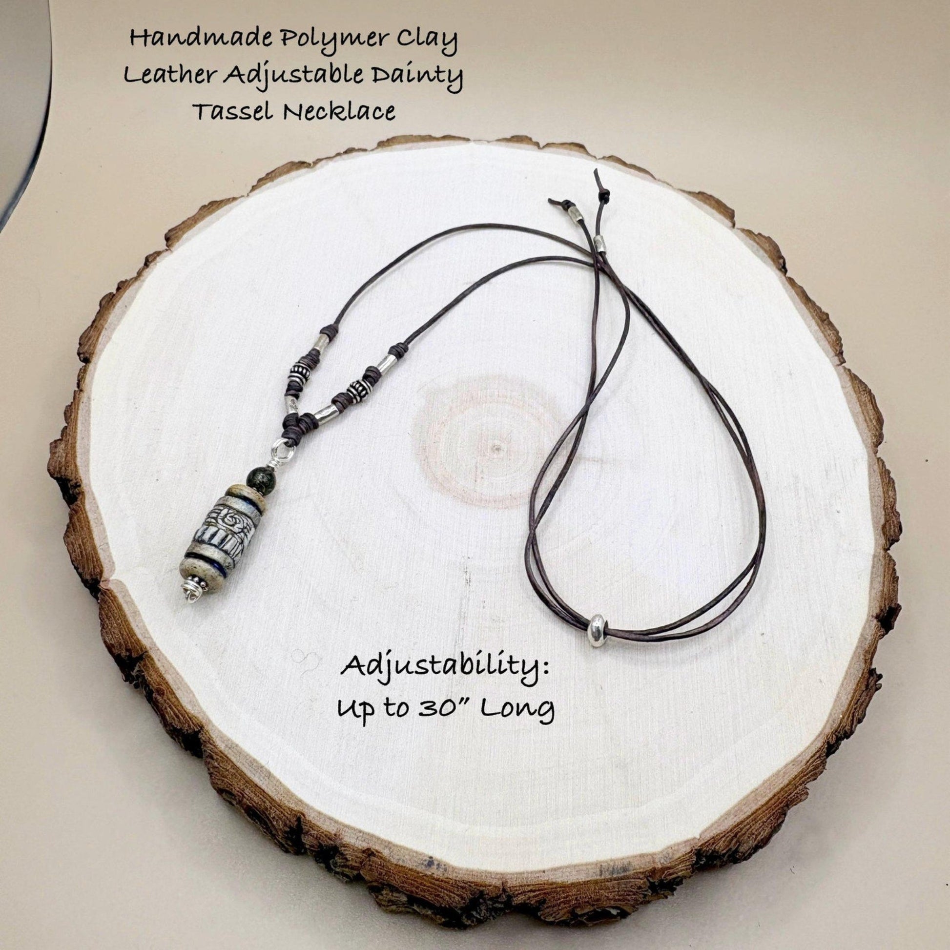 Handmade polymer clay necklace with tassel on a wooden surface