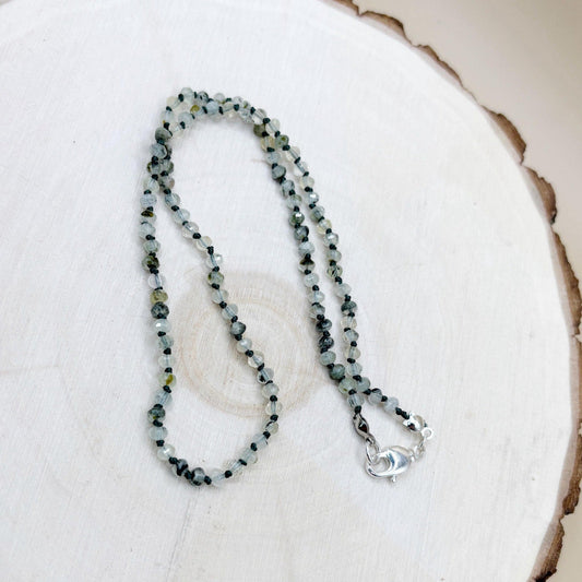 Green Beaded necklace on a white wood surface