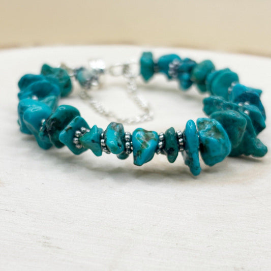 Turquoise beaded bracelet on a white wood surface-p