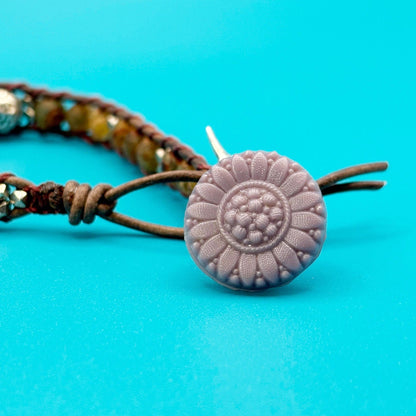 Bracelet with a textured flower-shaped button on a blue background