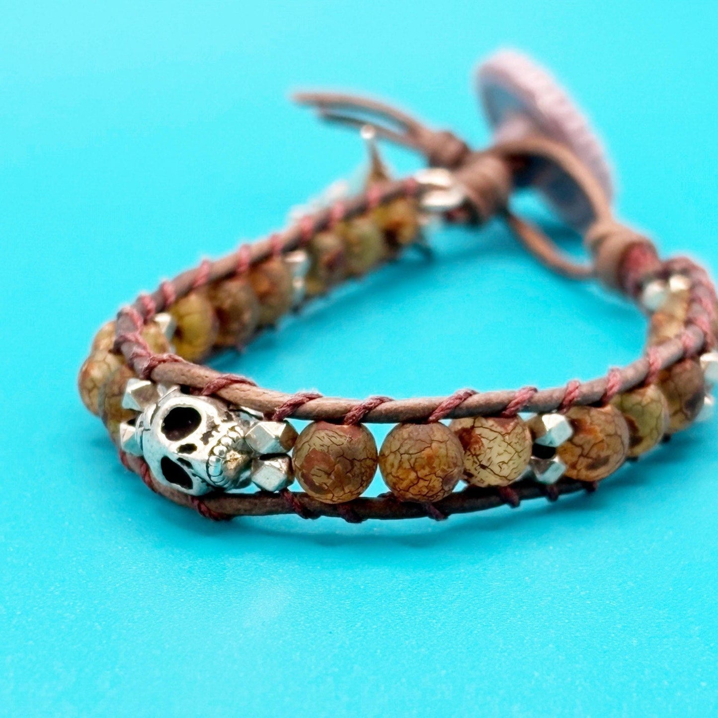 Bracelet with beads and skull charm on a blue background