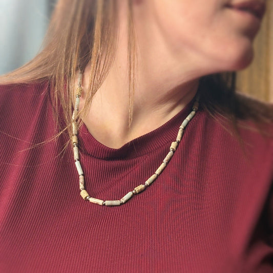 Close-up of a person wearing a beaded necklace with a blurred background-p