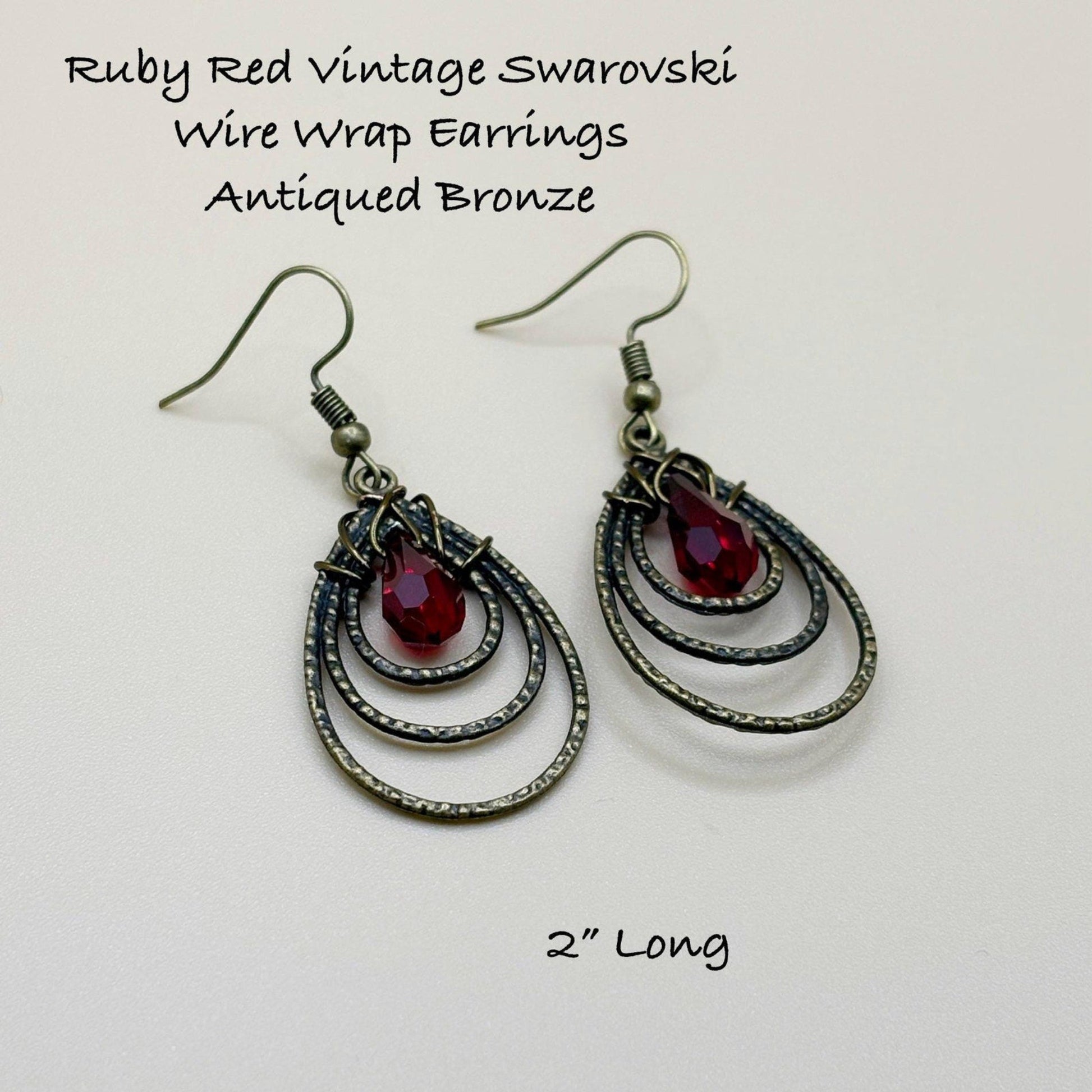 Ruby Red Vintage Swarovski Wire Wrap Earrings with Antiqued Bronze Finish on a light gray background