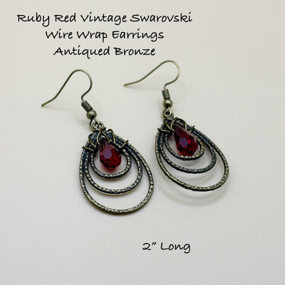 Ruby Red Vintage Swarovski Wire Wrap Earrings with Antiqued Bronze Finish on a light gray background