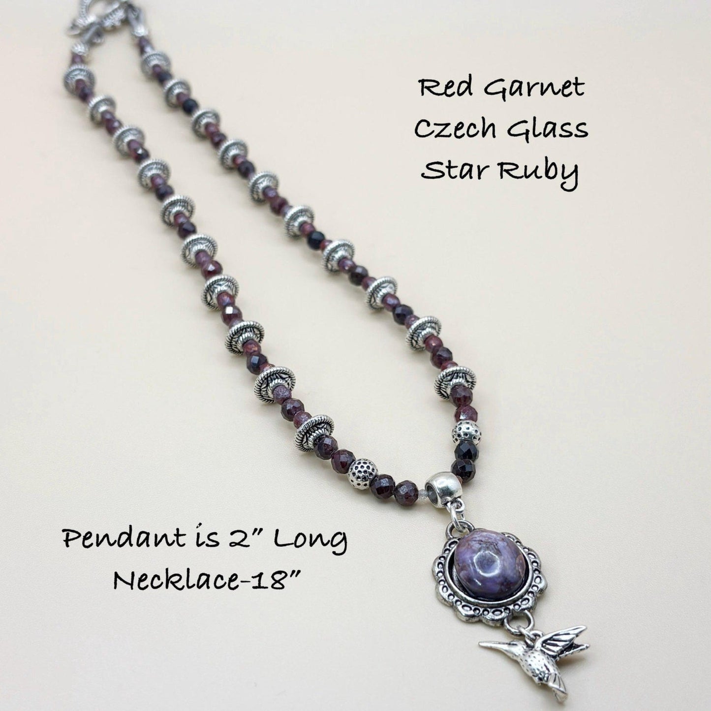 Necklace with red garnet, Czech glass, and star ruby beads on a light background