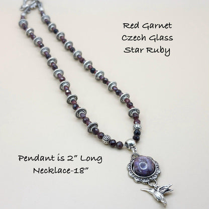 Necklace with red garnet, Czech glass, and star ruby beads on a light background