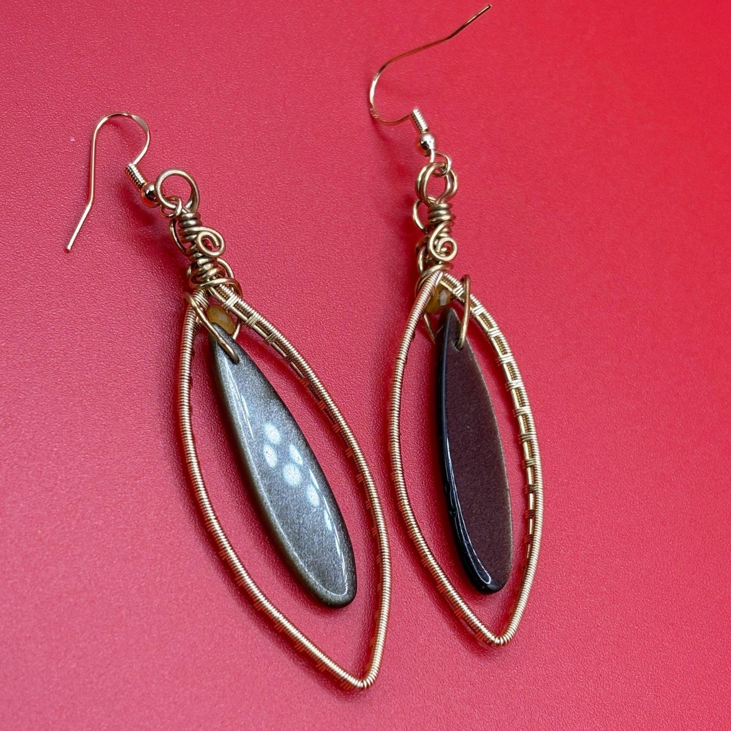 Pair of earrings with teardrop-shaped stones on a red background