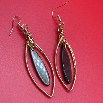 Pair of earrings with teardrop-shaped stones on a red background
