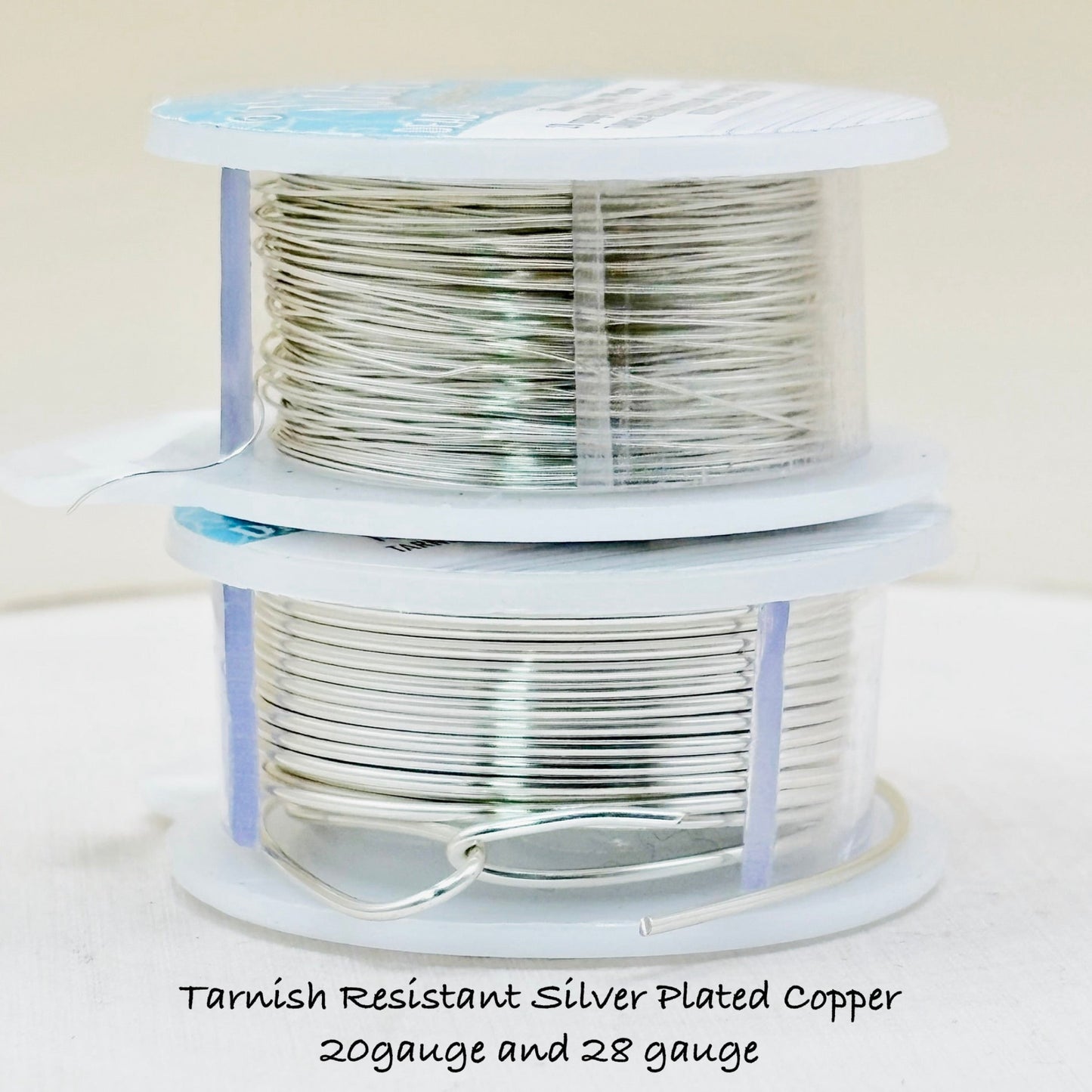 Two spools of tarnish-resistant silver-plated copper wire on a white background.