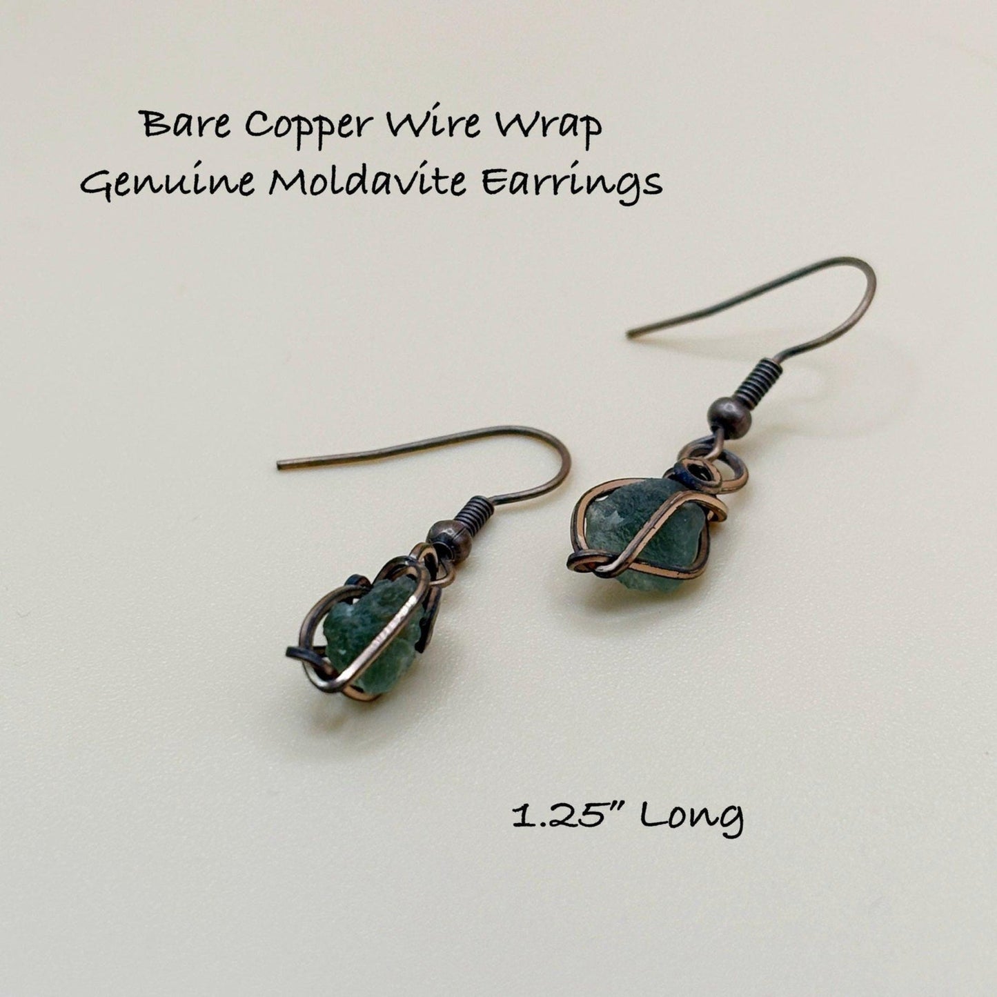 Bare copper wire wrap genuine moldavite earrings on a light background