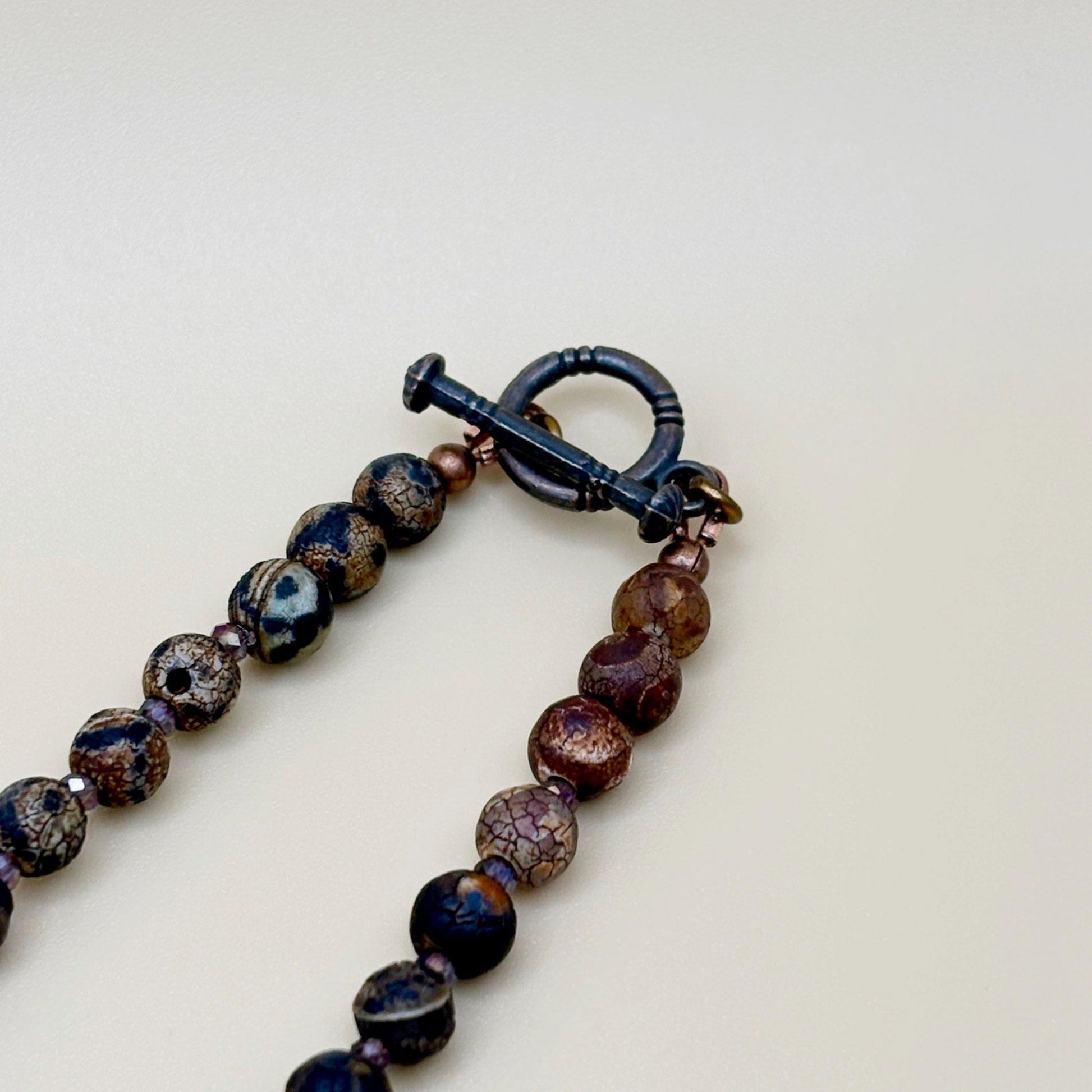 Necklace with brown and black beads on a light background
