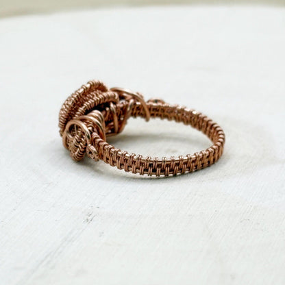 Copper wire ring on a light gray background