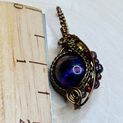 Ornate pendant with a blue gemstone on a white background