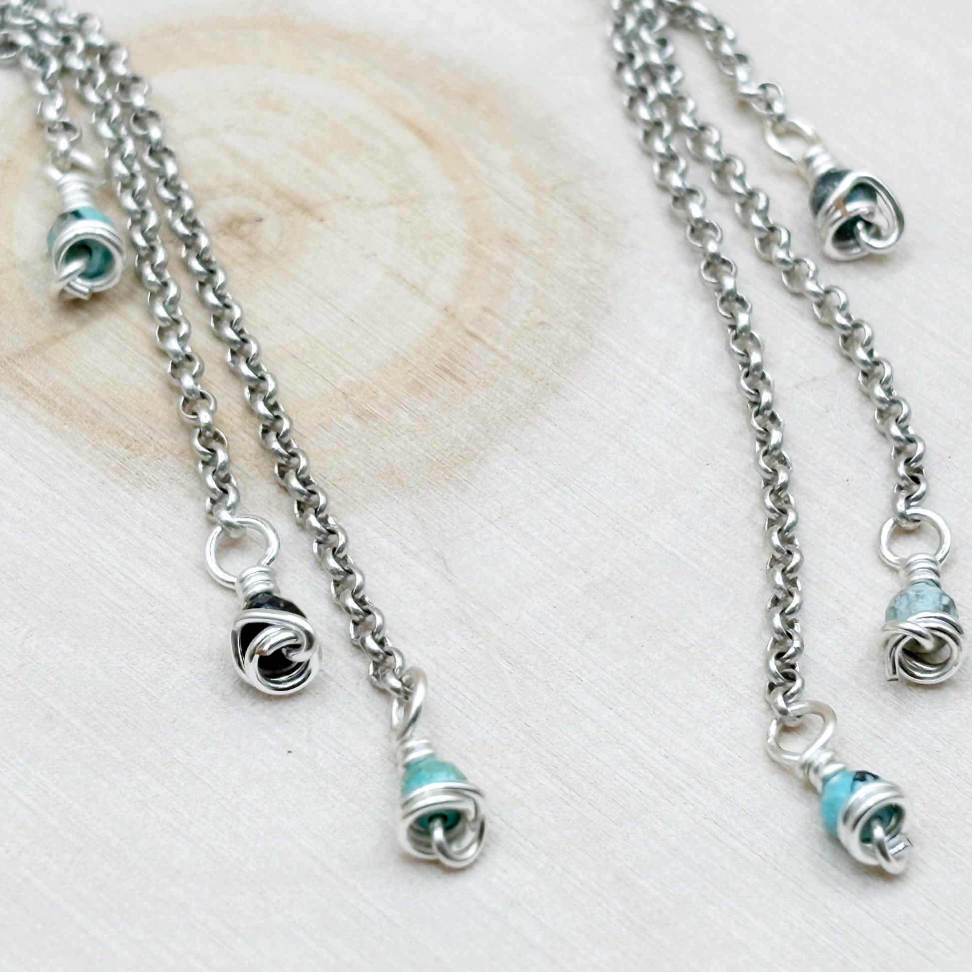 Silver earrings with turquoise beads on a light wooden surface